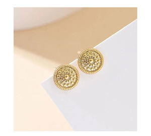 Detailed view of gold round stud earrings with beaded texture and retro metallic grain