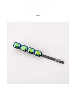 Détail de la barrette en métal noir avec quatre cristaux dégradés vert émeraude et bleu