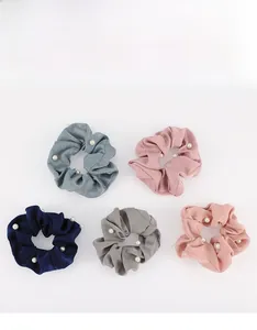 Détail de cinq chouchous en satin avec perles en marine, gris, bleu, rose et corail