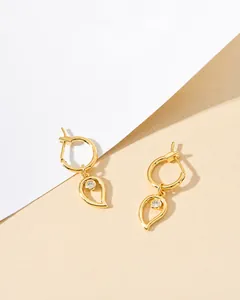 Detailed view of gold drop earrings featuring sleek circular hoops and teardrop pendants
