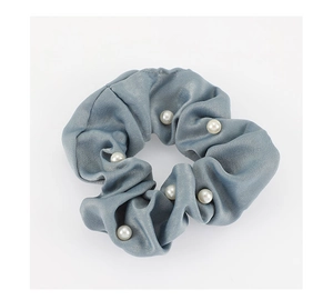 Vue détaillée du chouchou en satin bleu-gris orné de perles blanches élégantes
