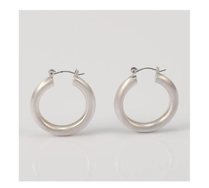 Gros plan détaillé des boucles d'oreilles créoles argent mat avec texture métal brossé