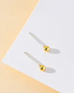 Detail view of minimalist polished gold ball stud earrings with S925 silver needles