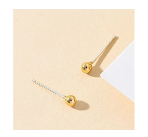 Detailed close-up of geometric golden ball stud earrings with S925 silver needles