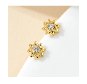 Macro shot of gold-plated hexagonal star stud earrings with central sparkling cubic zirconia