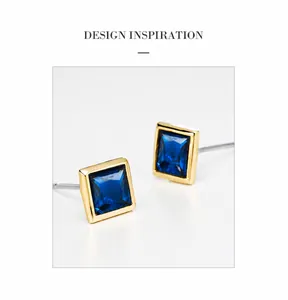 Close-up of geometric square blue crystal earrings with elegant gold plated borders
