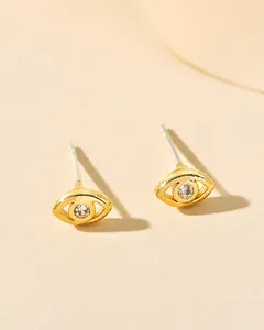 Detailed view of gold evil eye stud earring with sparkling central zircon inlay