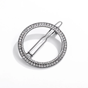 Macro detail of gunmetal geometric round hair clip with double-layer rhinestone pavé