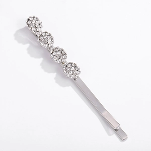 Eleganter silberner Haarschieber mit vier glitzernden Strass-Kugeln auf weißem Hintergrund