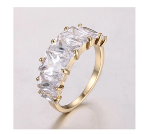 Macro view of gold plated ring featuring five square cut cubic zirconia in prong setting