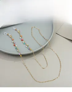 Detail of colorful beads on gold metal eyeglass chain with white silicone anti-slip loops