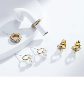Détails de créoles serties de zircons, bagues perles et boucles d'oreilles serpent