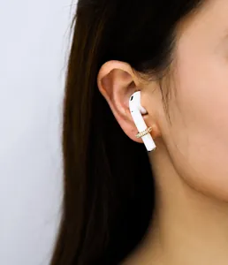 Dettaglio macro dell'accessorio per auricolari placcato oro con pavé di zirconi lucidi
