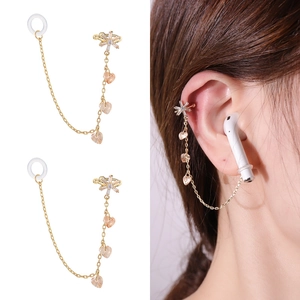 Detail of gold anti-lost ear cuff with zircon stars and heart charms for earbuds