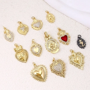 Vintage punk gold pendants featuring heart, crown, and cross designs on stone surface