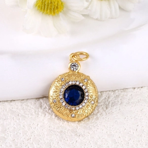 Pendentif vintage doré avec centre saphir bleu foncé et motif de relief en rayons de soleil