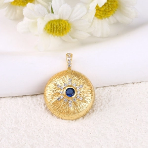 Pendentif soleil en or avec pierre centrale bleu foncé et petits cristaux brillants
