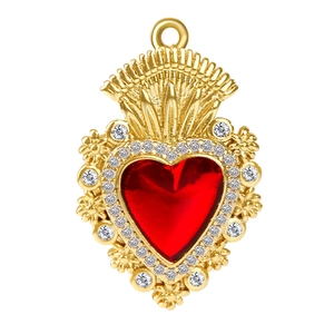 Macro detail of a golden sacred heart pendant with a red gemstone and white crystals