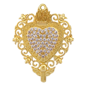 Detail view of gold-plated sacred heart pendant with intricate filigree and white gemstones
