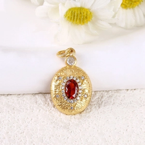 Pendentif vintage doré avec cristal rouge et zircon blanc sur fond pierre blanche