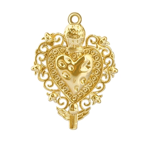 Macro detail of golden vintage heart pendant with ornate filigree and bird embossments