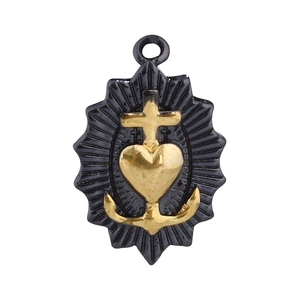 Detailed heart-shaped religious pendant with gold cross and anchor motifs in macro view