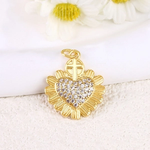 Golden heart pendant with sparkling cubic zirconia and cross element on white background