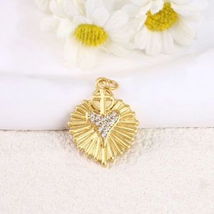 Detail of gold heart pendant with cross and white zircon pavé on daisy background