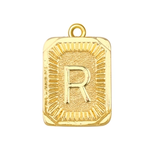 Detalle de un colgante rectangular bañado en oro con letra R en relieve y borde de rayos de sol
