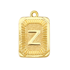 Detalle de un colgante cuadrado bañado en oro con la letra Z y grabado de sol radiante