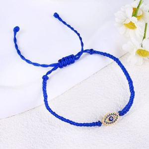Detail of blue braided evil eye bracelet with hand-woven cord and crystal pendant