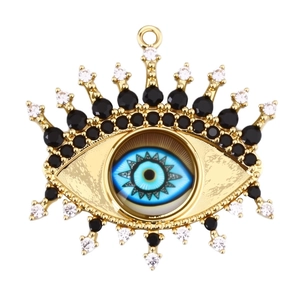 Golden Turkish Evil Eye pendant with blue inlay and black zircon stones on white background