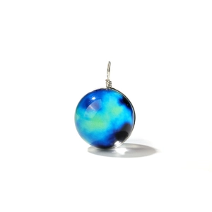 Detailansicht eines kosmischen Glaskugelanhängers mit Spiralnebel und silberner Wicklung