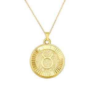 Detail of gold coin necklace with embossed Taurus zodiac sign and sunburst texture
