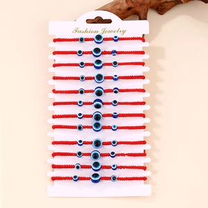 Set di 12 braccialetti in corda rossa intrecciata con perline malocchio su cartoncino