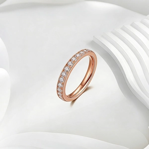 Close-up of rose gold titanium ring with pavé set cubic zirconia stones on white background