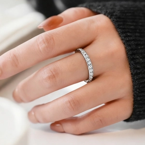 Close-up of minimalist titanium steel ring with sparkling stones worn on index finger