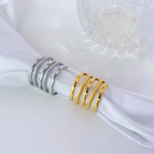 Lot de cinq bagues minimalistes empilables en or et argent sur un tissu de soie blanche