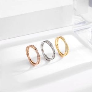 Dettaglio di anelli incrociati in tre colori oro e argento con pavé di cristalli scintillanti