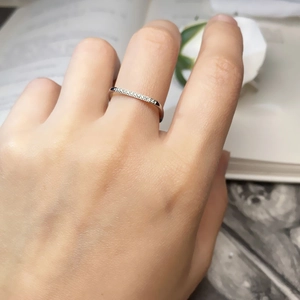 Bague minimaliste en titane or 18k avec micro-pavé de diamants sur main de femme