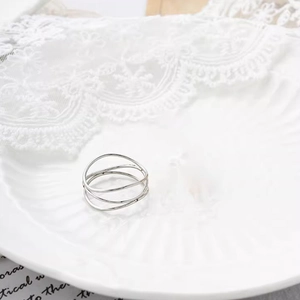 Macro de un anillo multicapa de acero de titanio plateado sobre una elegante bandeja de porcelana