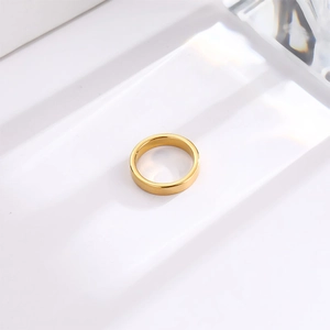 Polished 4mm gold titanium steel ring on white minimalist background for women