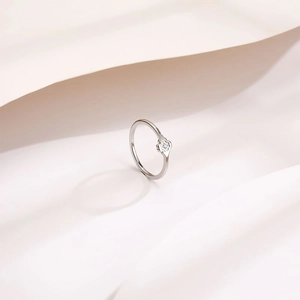 Minimalist silver flower ring with a single diamond inlay and delicate polished band