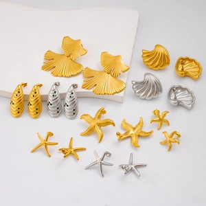 Détail de boucles d'oreilles en acier inoxydable avec motifs étoile de mer et coquillages