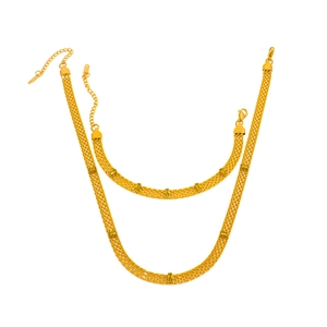 Close-up of gold woven mesh chain jewelry set with rectangular green stones
