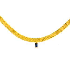 Vue macro d'une chaîne maille dorée multi-rangs avec un pendentif en zircon bleu