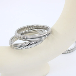 Detail of silver stainless steel Tubogas stretch bracelets on a minimalist stand