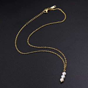 Elegante goldene Titankette mit drei natürlichen Süßwasserperlen auf schwarzem Hintergrund