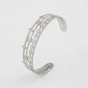 Detailed view of silver C-shaped multilayer cuff bracelet with beads and floral motifs