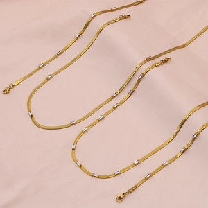 Detail of gold snake chain necklace with rectangular zircon stones and lobster clasp